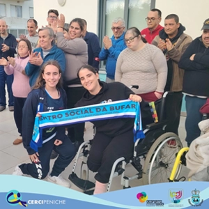 Grupo de pessoas apoiadas da Cercipeniche e jogadores do clube de futsal da Bufarda com a faixa do clube